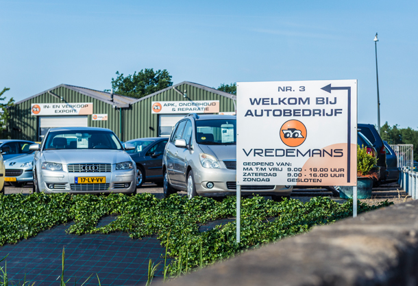 Het terrein van Vredemans aan de Stationsweg in Teuge, met het welkomstbord en de groene loodsen